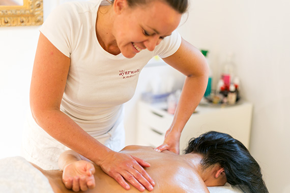 Kerstin, die einer Klientin eine Ganzkörpermassage gibt.